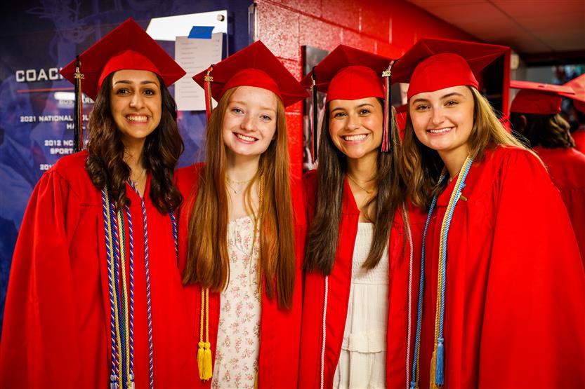 Students in red robes graduate